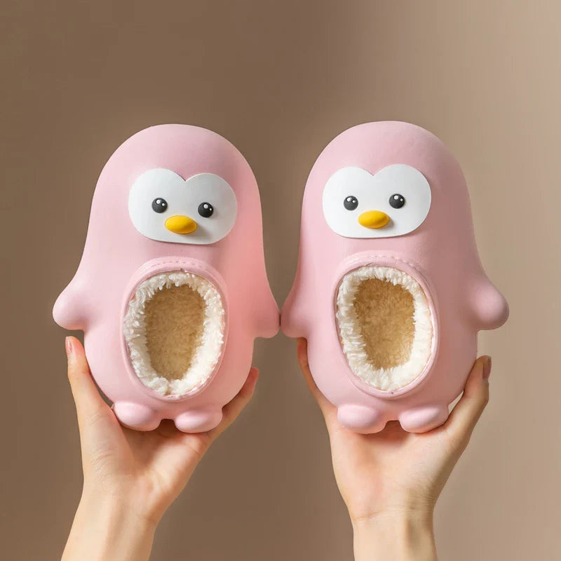 Pair of pink penguin slippers with flipper details and soft-lined openings