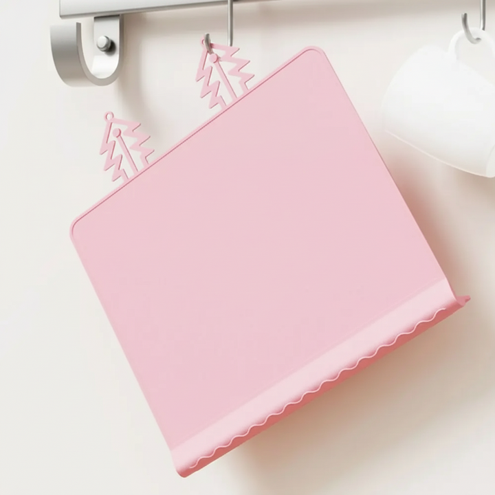 Pink silicone placemat hanging from hooks by its tree-shaped tabs