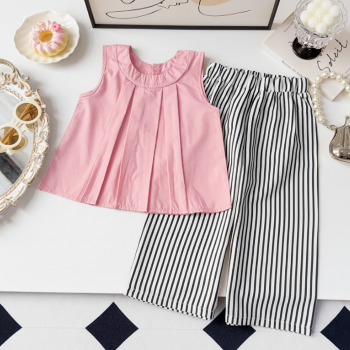 Pink pleated sleeveless top with black-and-white striped cropped pants