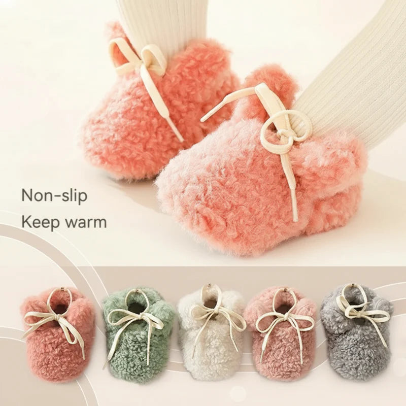 Pink plush baby shoes with bow-tied laces and a row of colors below