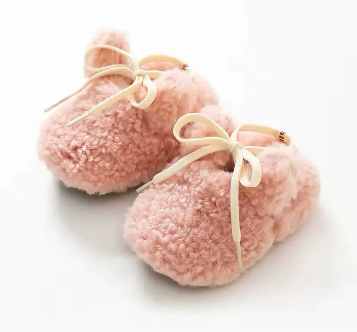 Pink plush bunny baby slippers with cream bow ties and small ears