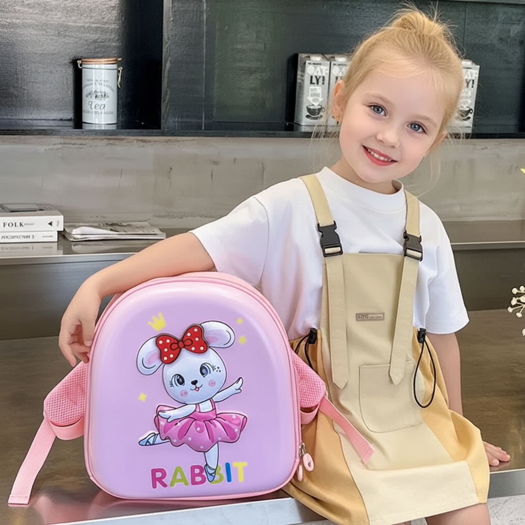 Seated child holding a pink backpack with a dancing rabbit design