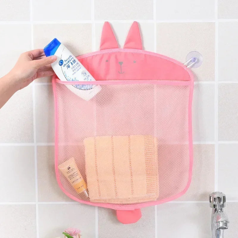 Pink rabbit-shaped mesh bathroom organizer holding toiletries on a tiled wall