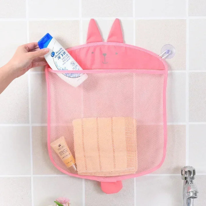 Pink rabbit-shaped mesh bathroom organizer holding toiletries on a tiled wall