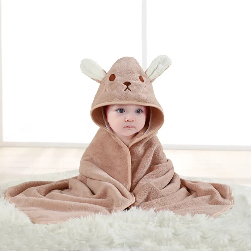Child wrapped in a pink rabbit hooded bath towel with long ears