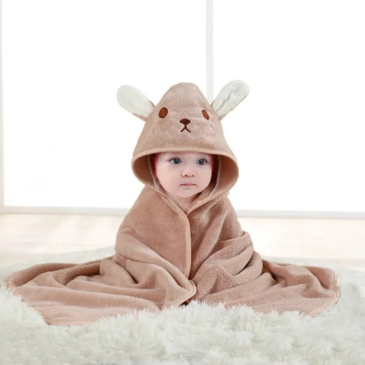 Child wrapped in a pink rabbit hooded bath towel with long ears