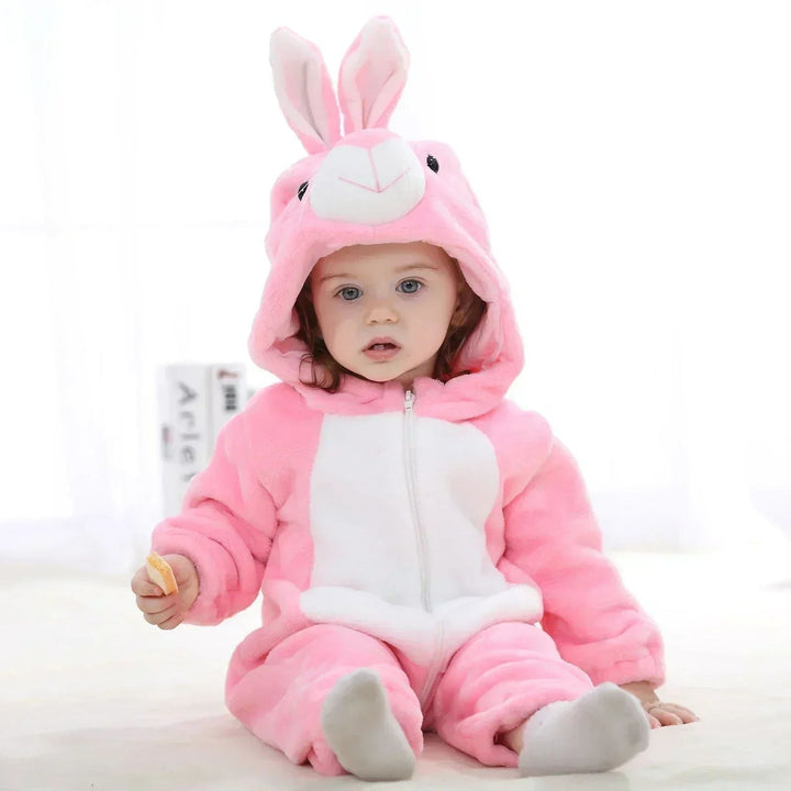 Baby seated in a pink rabbit onesie with upright ears and a white belly