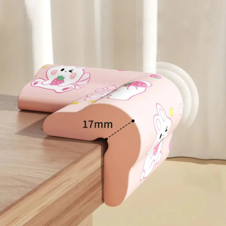 Pink rabbit-print corner cover fitted to a table, with a 17 mm measurement marked.