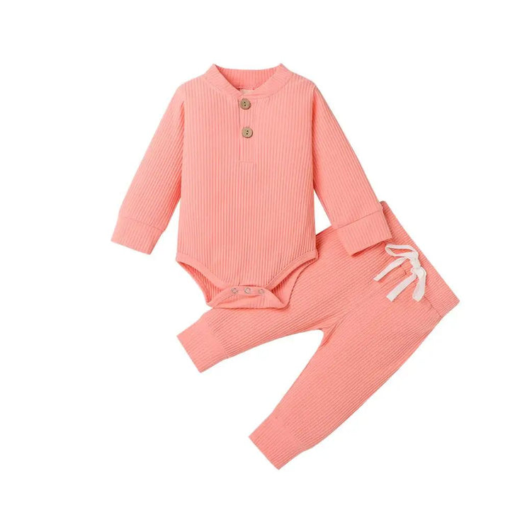 Pink ribbed baby bodysuit and matching pants with a white waist tie