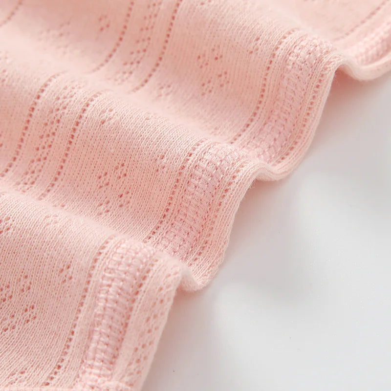 Pink cotton fabric close-up showing ribbed texture and openwork knit details