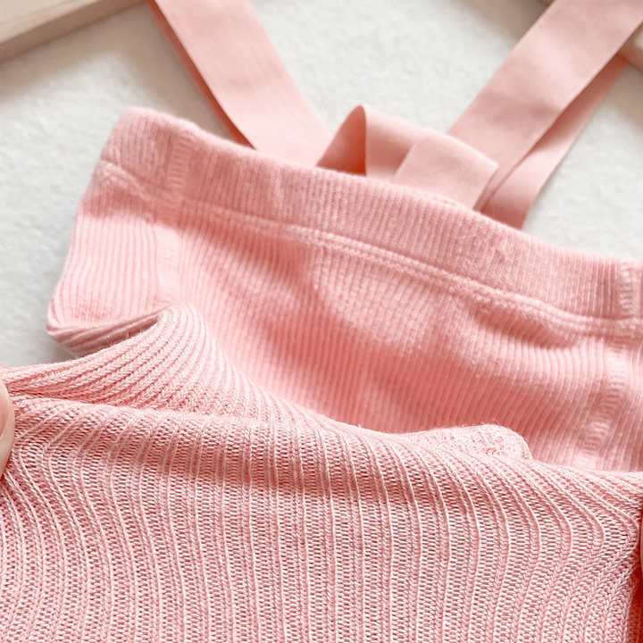 Close-up of pink ribbed cotton leggings and matching suspender straps