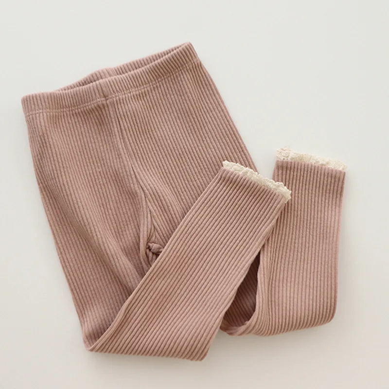 Pink ribbed leggings with an elastic waistband and pale lace edging at the cuffs.