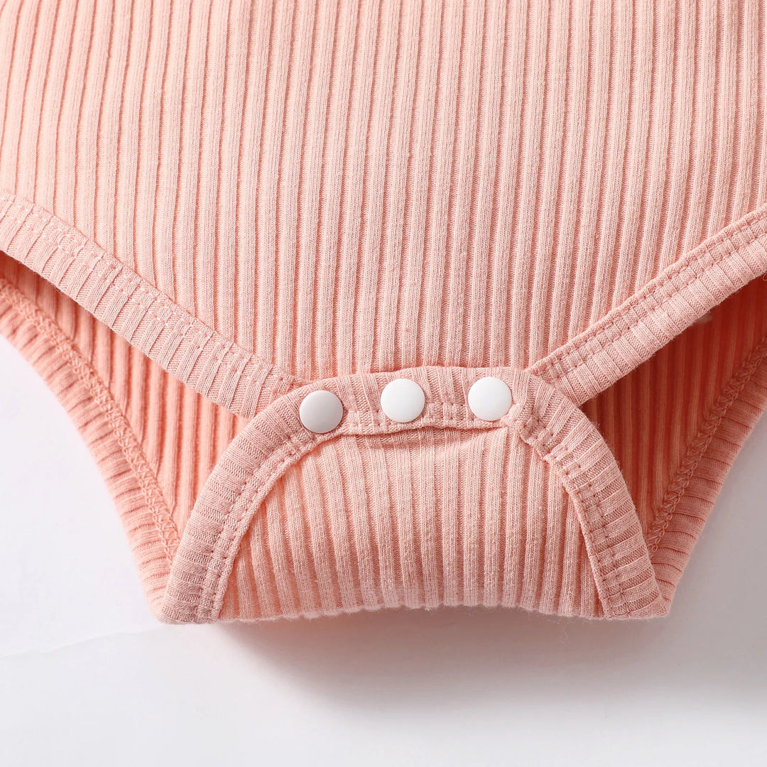 Three bottom snaps on the pink ribbed romper for diaper changes