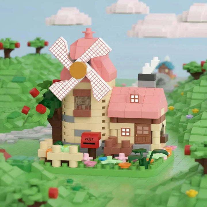 Pink-roof windmill block model beside an apple tree in a miniature countryside scene.