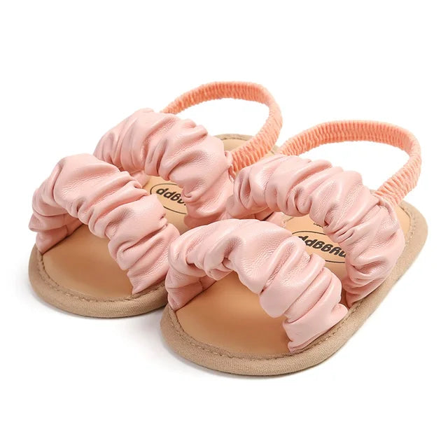Pink baby sandals with gathered front straps and elastic heel straps