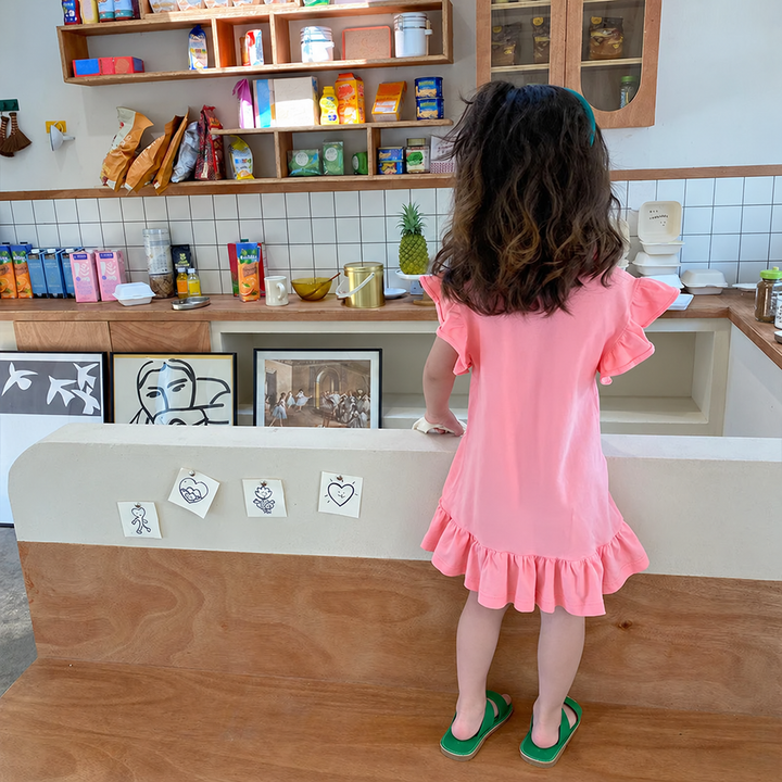 Back view of the pink dress with ruffled sleeves and a ruffled hem