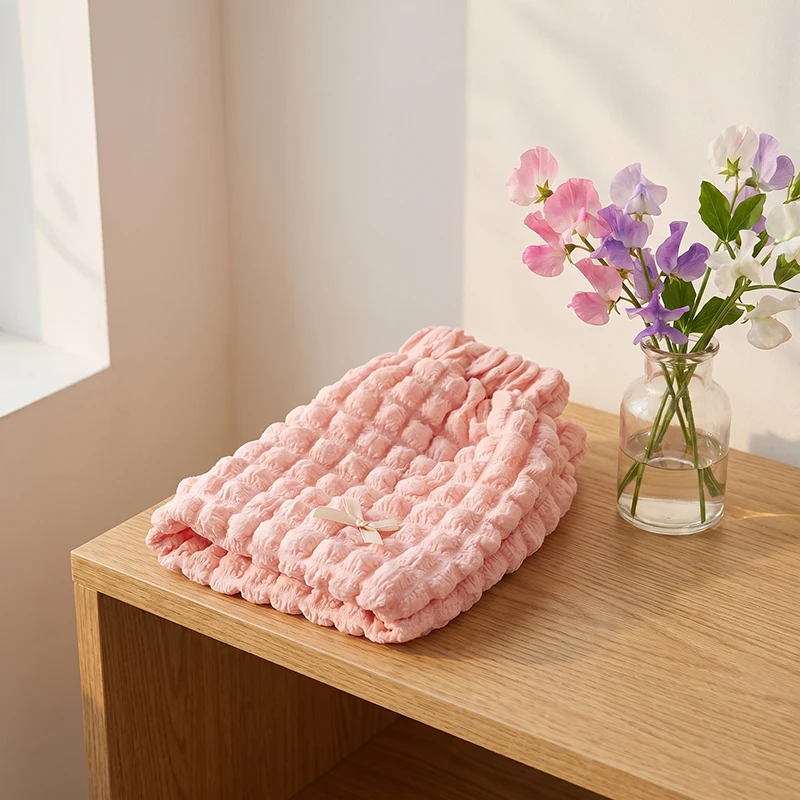 Pink ruffle shorts with cream bows displayed beside a vase of flowers