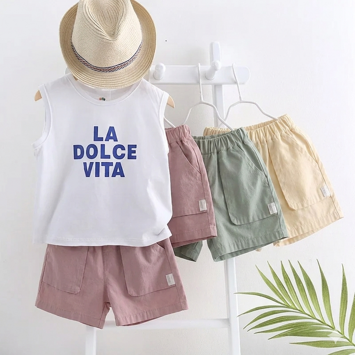 Pink shorts styled with a white sleeveless top beside hanging sage green and light beige shorts.