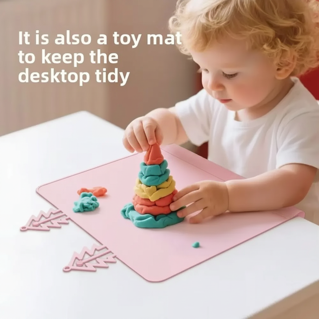 Child playing with colorful dough on a pink silicone placemat