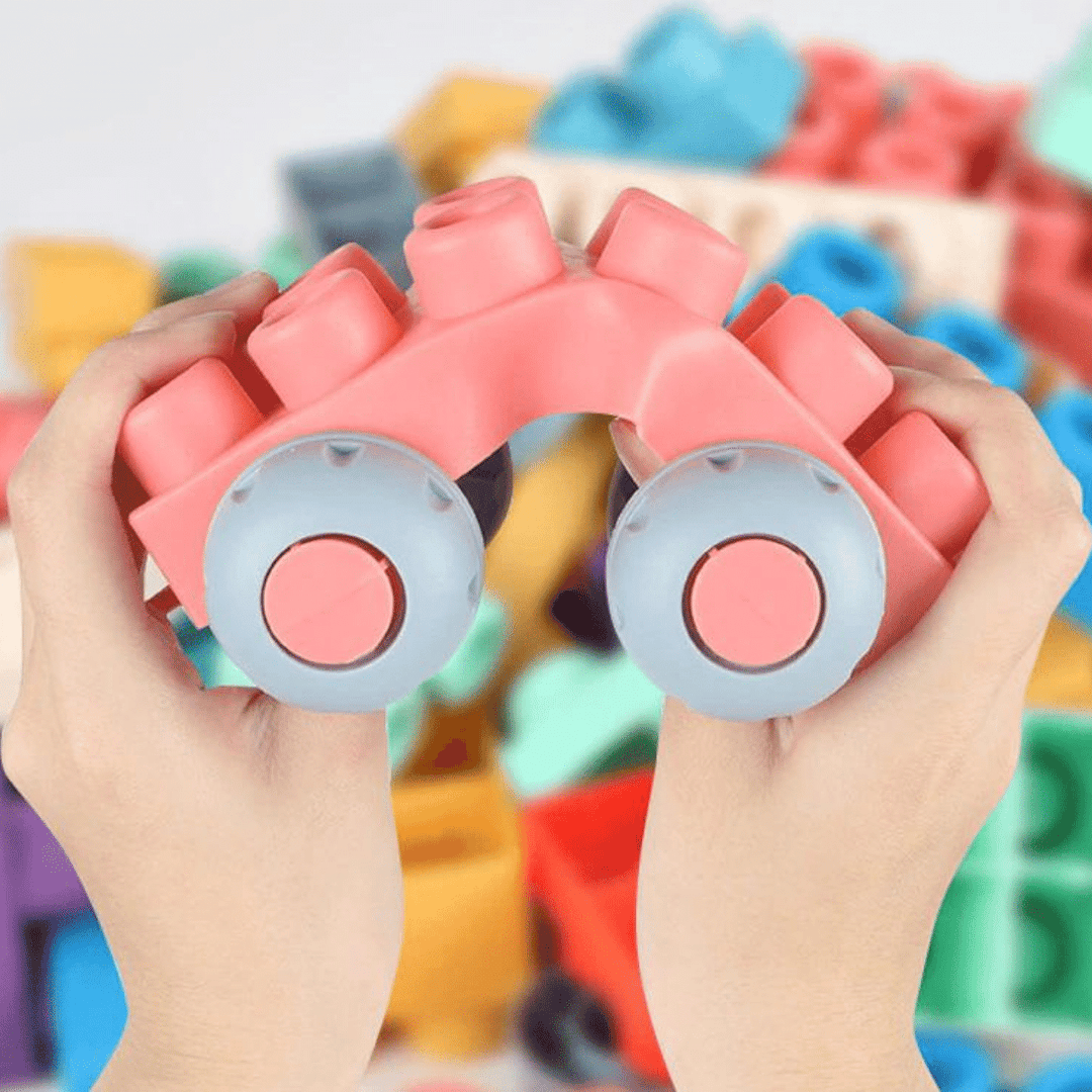Hands bending a pink silicone block vehicle with gray wheels