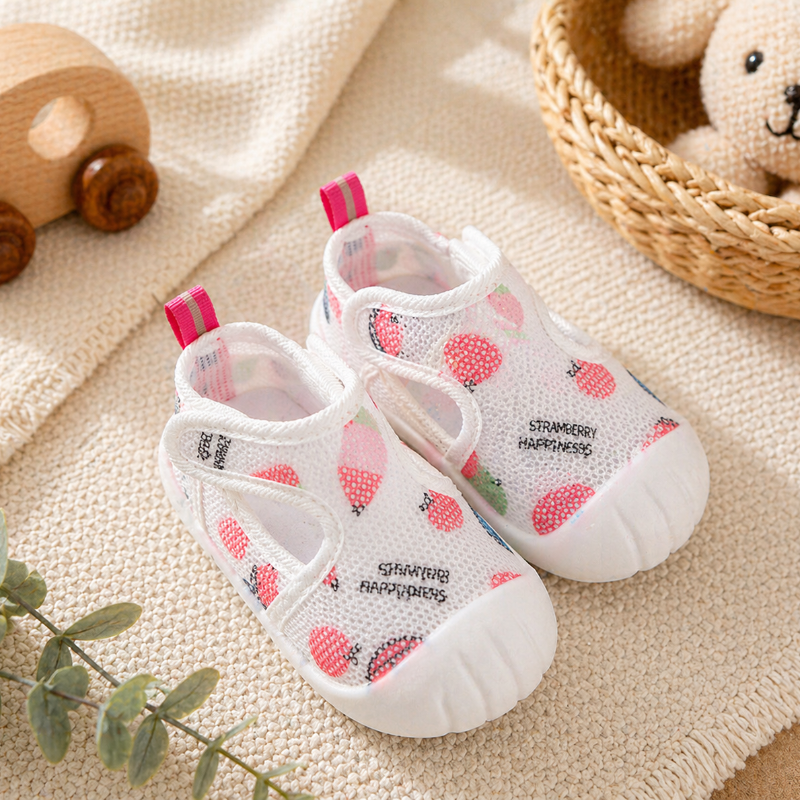 Pink strawberry-print baby strap shoes with pink heel tabs and white toe caps.