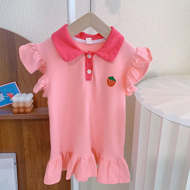 Pink children's dress on a hanger with a contrasting collar, strawberry detail, ruffled sleeves and hem