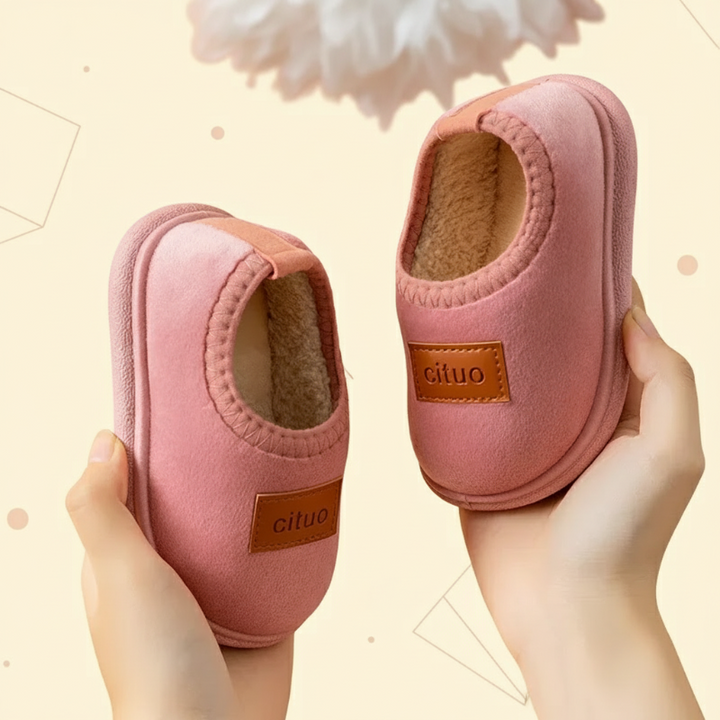 Pink suede slip-on slippers with matching trim, tan patches, and soft linings