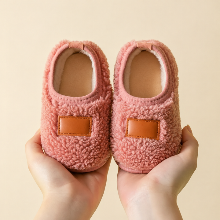 Pink textured winter slippers with tan patches and cream-colored opening trim