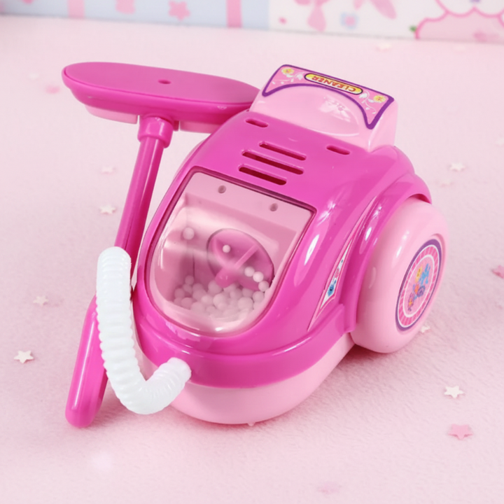 Pink toy canister vacuum with a flexible hose, floor attachment, and clear front compartment