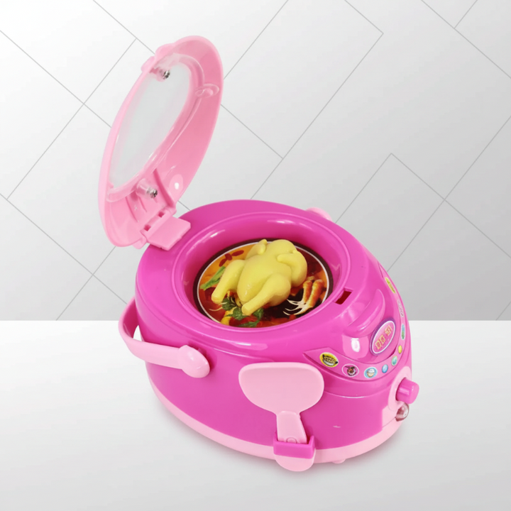 Pink toy rice cooker with an open lid, front spoon, and pretend food inside