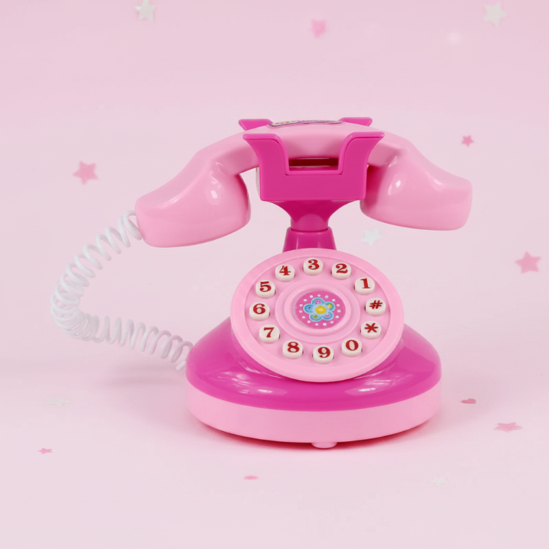 Pink toy telephone with a coiled cord and numbered dial