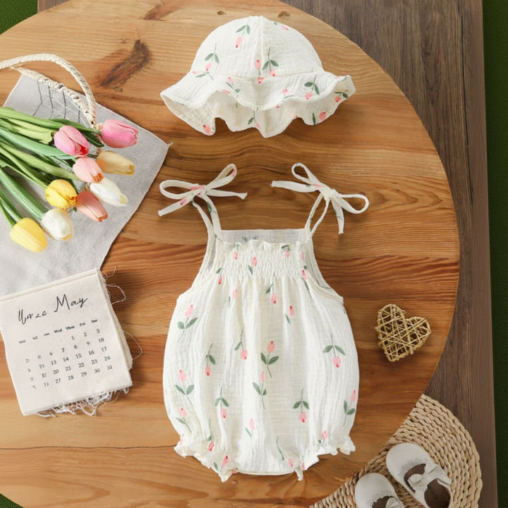 Pink tulip-print baby bodysuit with tie shoulders and a matching hat