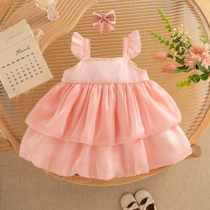 Back of the pink mesh dress with ruffled shoulder straps and a two-tier skirt