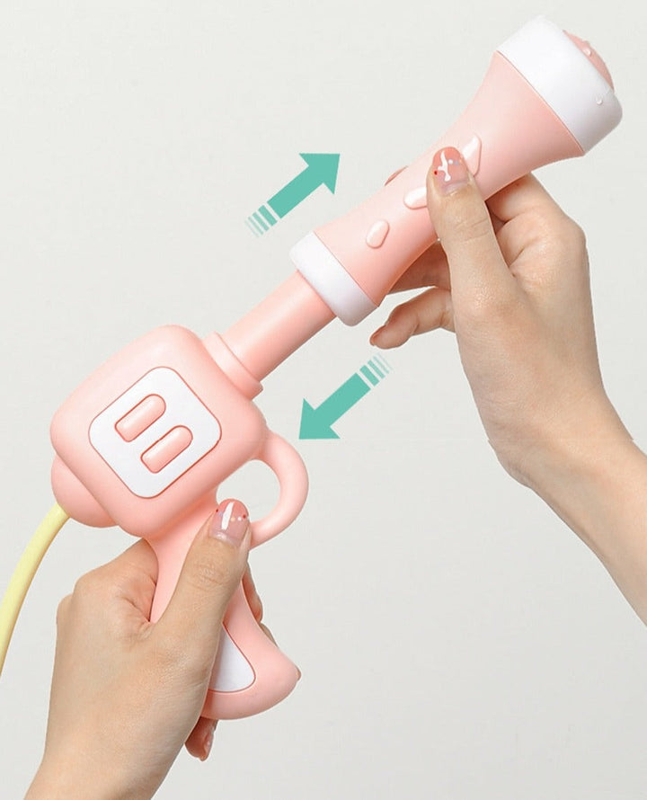Hands sliding the barrel of a pink backpack water blaster