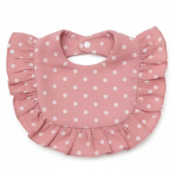 Pink cotton baby bib with white polka dots, ruffled trim, and neck snaps