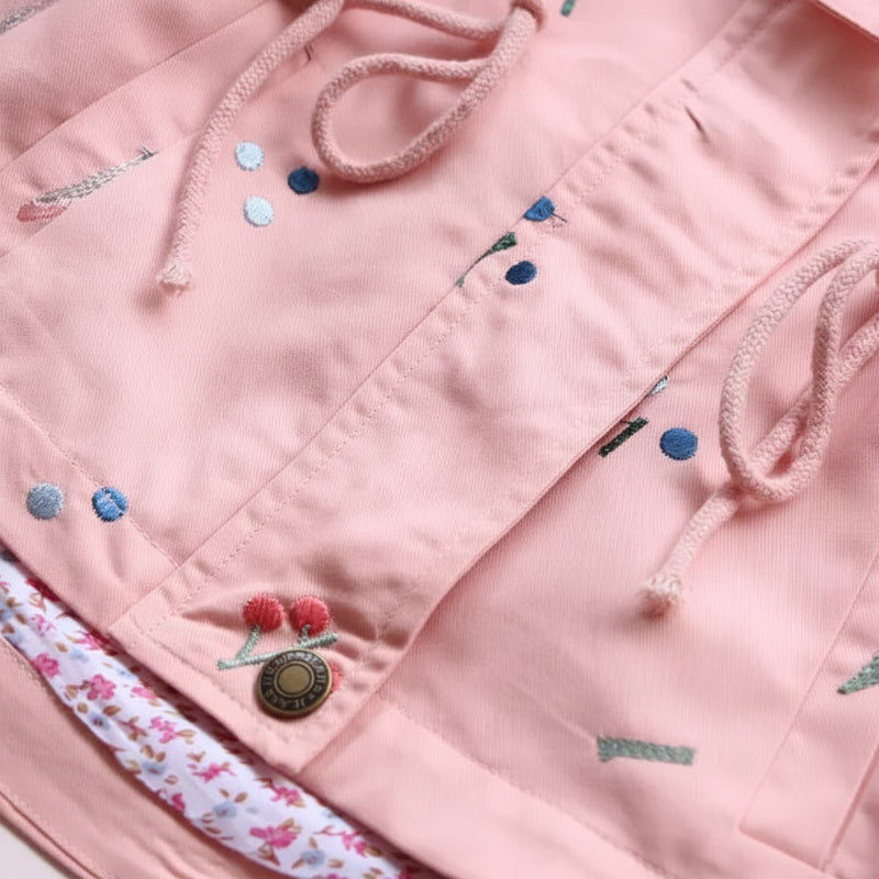 Pink windbreaker front flap with snap buttons and nature-inspired motifs