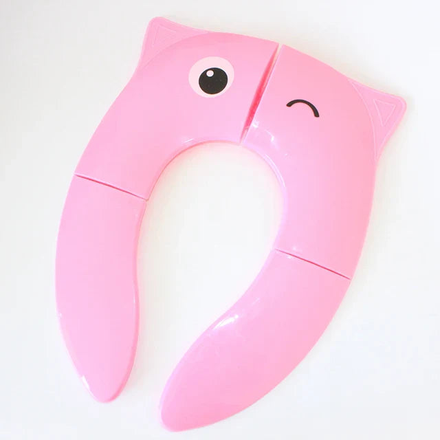 Pink folding toilet training seat with a winking animal face