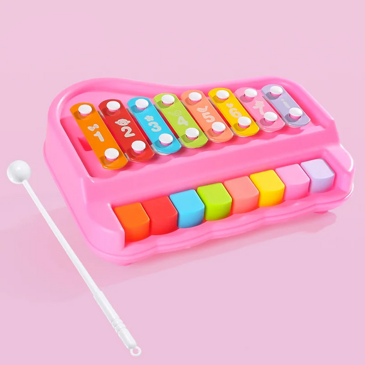 Pink xylophone and piano toy with eight colorful bars and a white mallet beside it