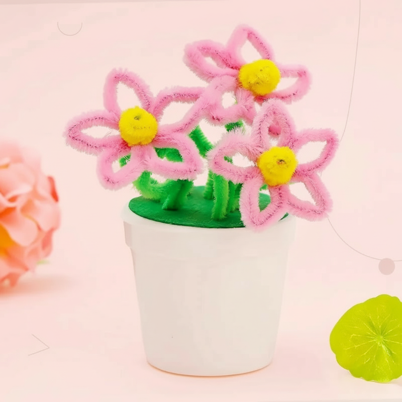 Pink loop-petal flowers with yellow centers and green stems in a white pot