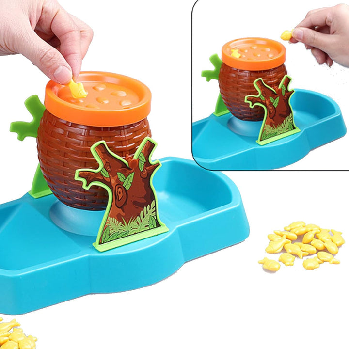 Hands adding yellow fish to the orange-rimmed balancing barrel