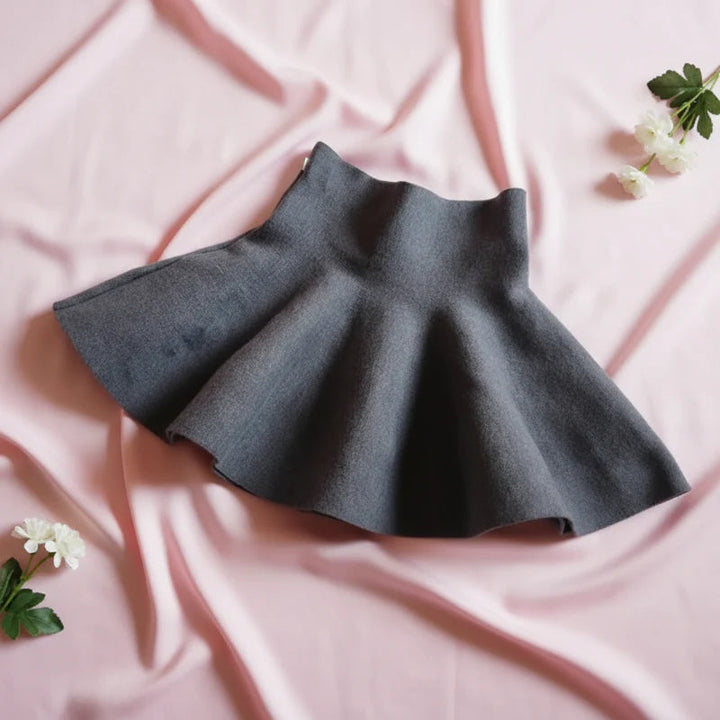 Plain gray knit skirt showing its wide waistband and flared hem