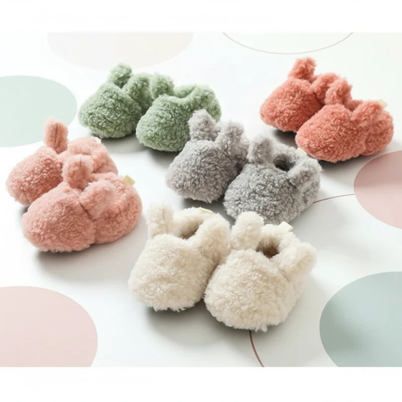 Five pairs of plush baby booties in assorted colors arranged together