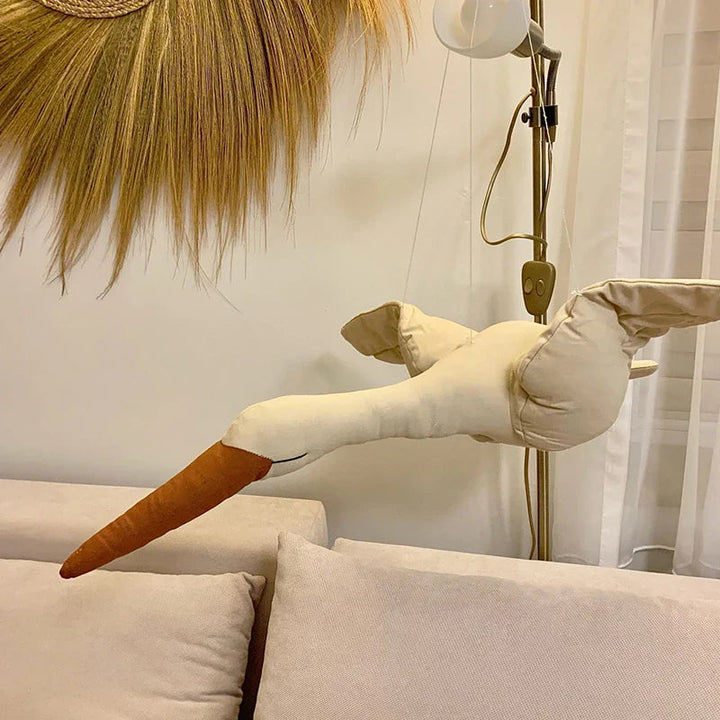 Soft swan decoration displayed above a sofa with its long neck extended