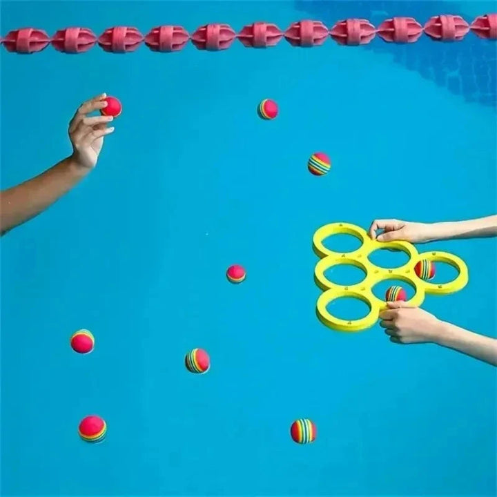 Players tossing colorful balls toward a yellow ring target in a swimming pool