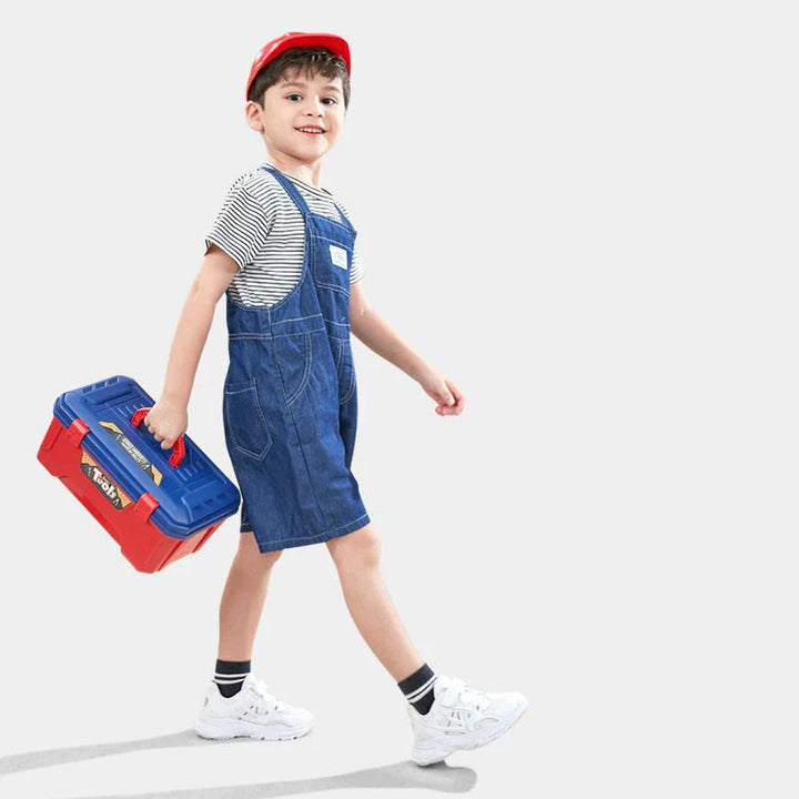 Child carrying a red-and-blue toy toolbox by its handle