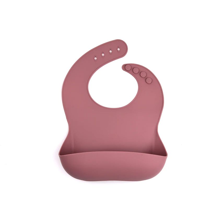 Powder rose silicone bib with neck adjustment holes and a curved food pocket.