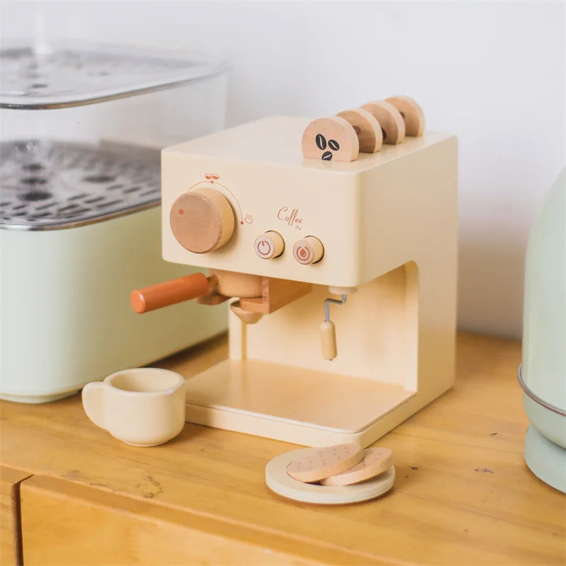 Wooden toy espresso machine on a kitchen counter with a cup, saucer, and pretend cookies.