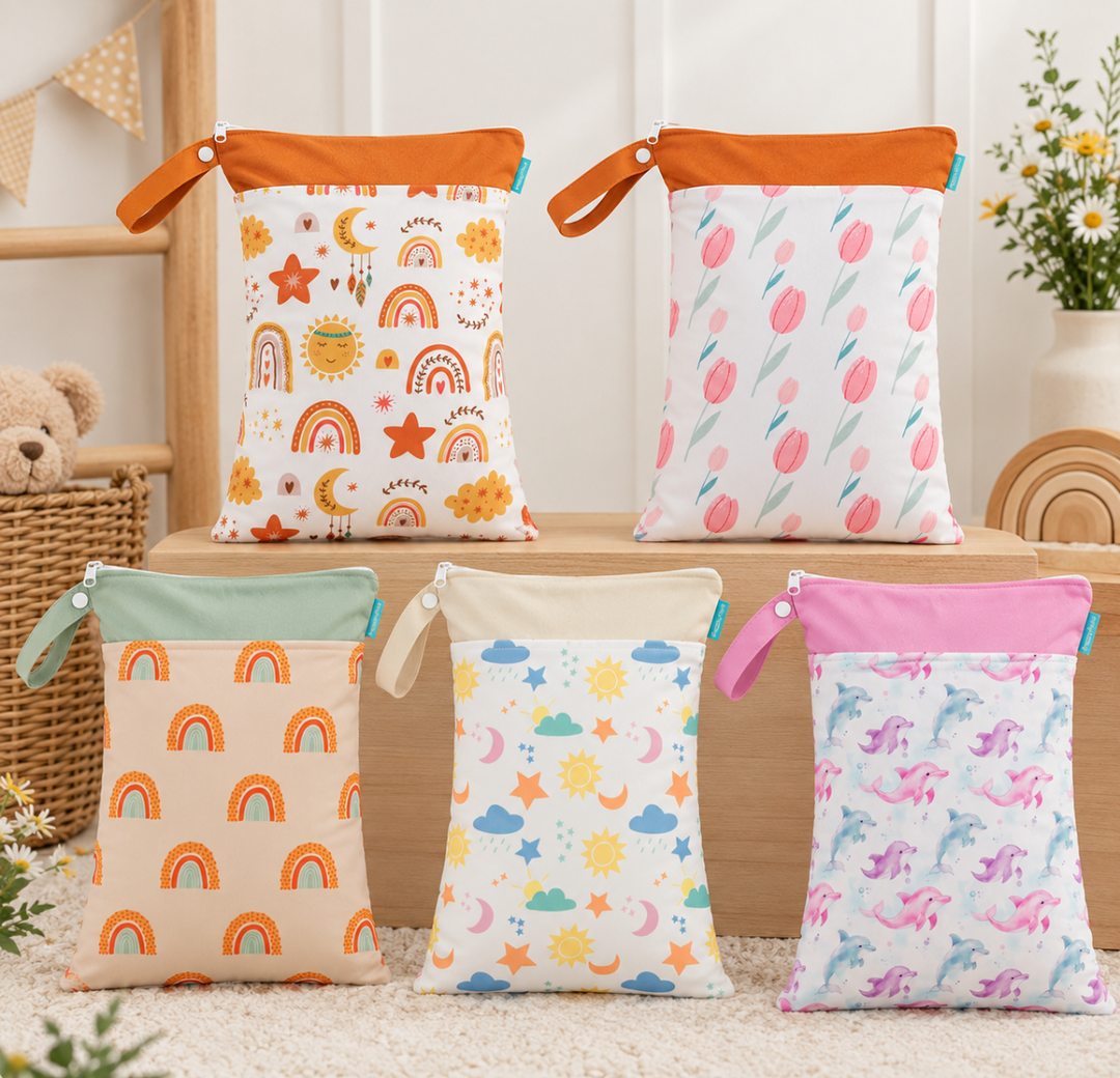 Five printed diaper wet bags with zippered tops and snap loops in assorted colors