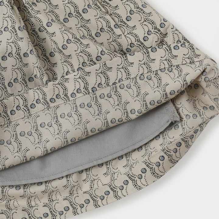 Close-up of printed skirt fabric with the hem lifted to show the lining