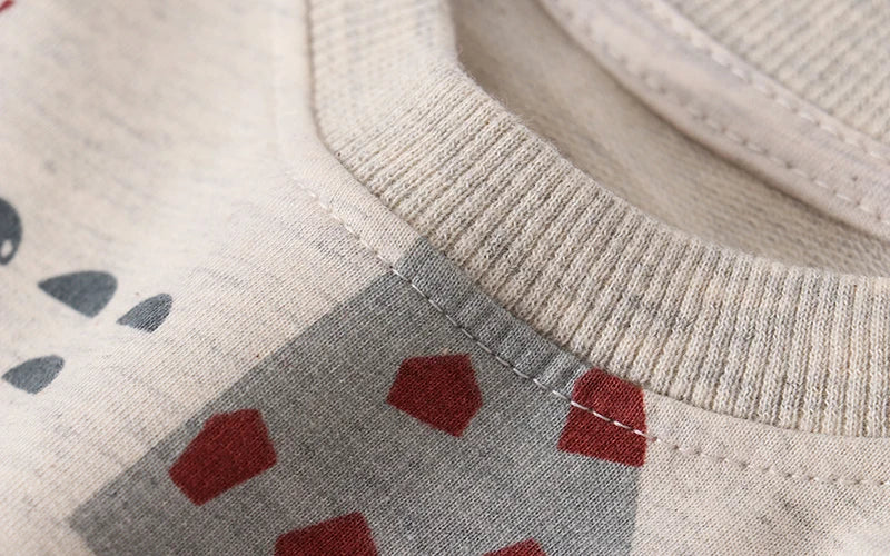 Close-up of neckline stitching and ribbing on the beige printed sweatshirt